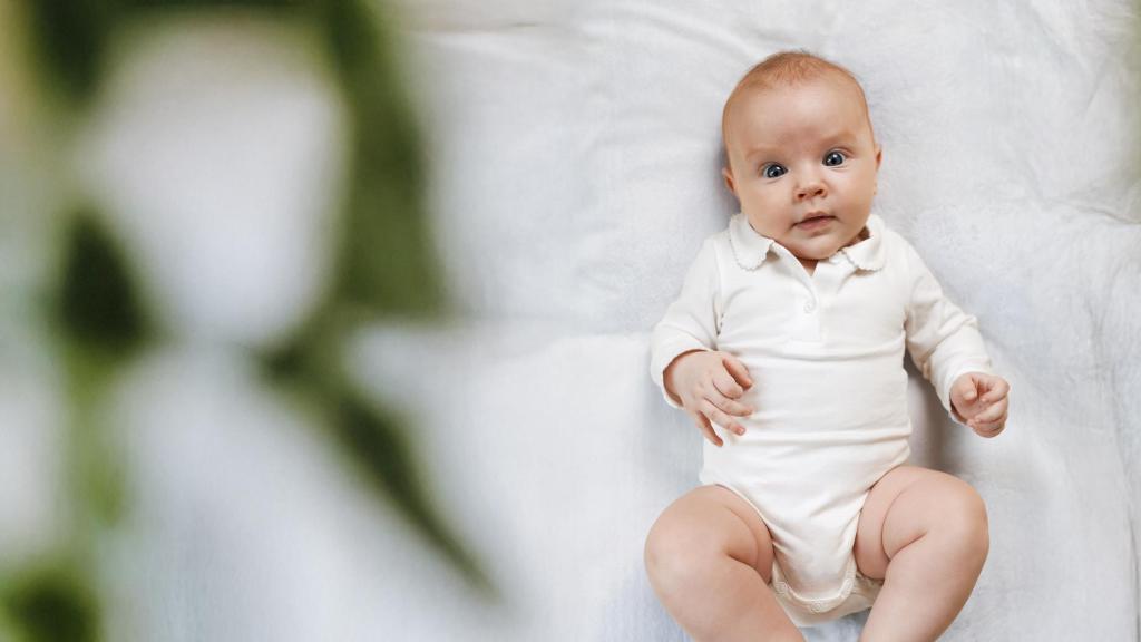 A baby looks up at the camera with a smile - for an article by Alex Noel, writer and digital marketer.